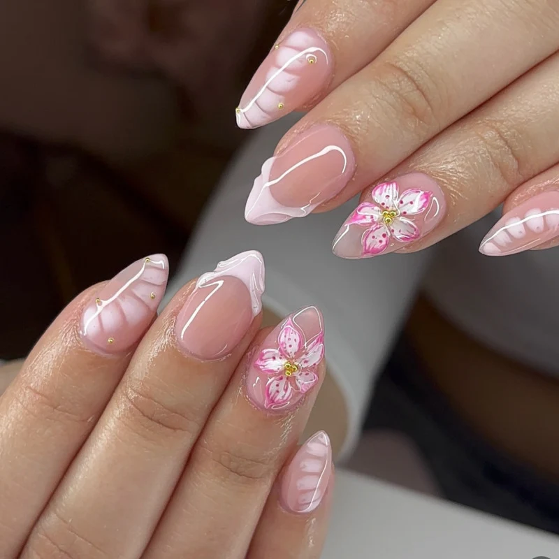 Kunstvolle Nagelverlängerungen mit floralem Design und Glitzerakzenten Karnz