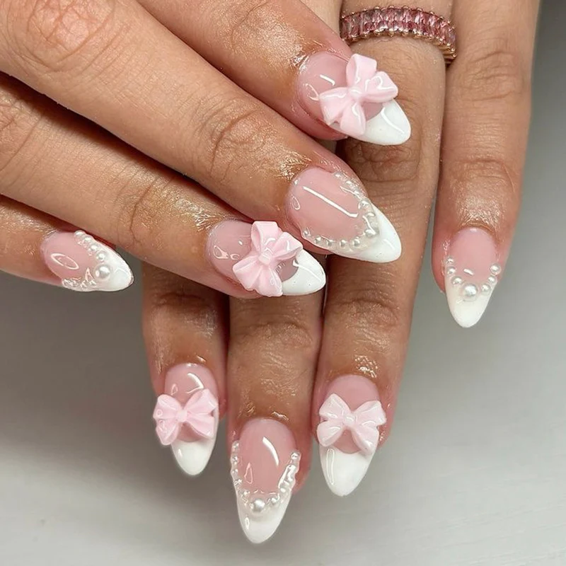Kunstvolle Stiletto-Nägel mit zarten Schleifenakzenten Karnz