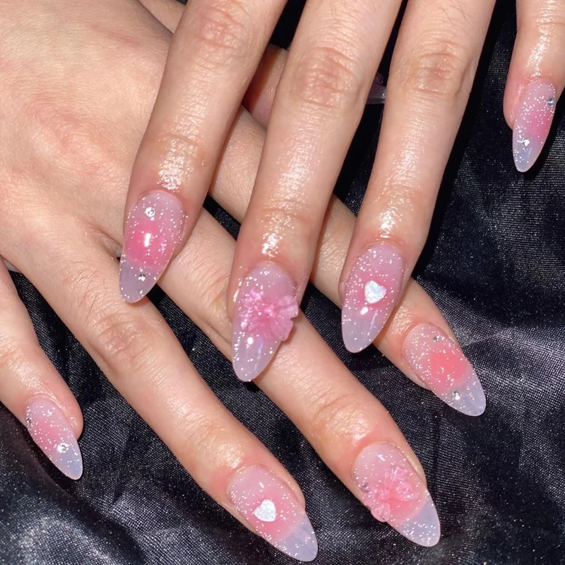 Kunstvolle Stiletto-Nägel mit floralem Design und Glitzer Karnz