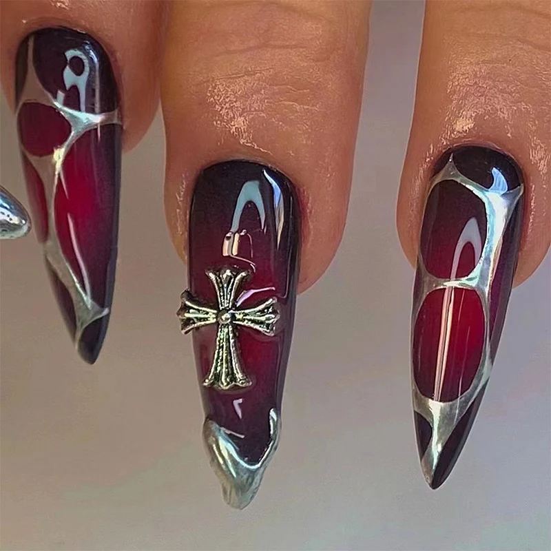Kunstvolle Stiletto-Nägel mit eleganter Kreuzverzierung Karnz
