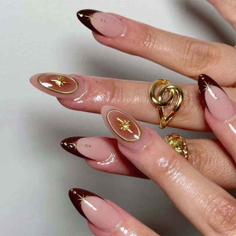 Kunstvolle Stiletto-Nägel mit eleganten Goldverzierungen Karnz