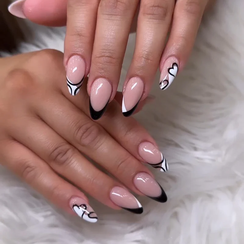 Kunstvolle Stiletto-Nägel mit elegantem Schwarz-Weiß-Design Karnz