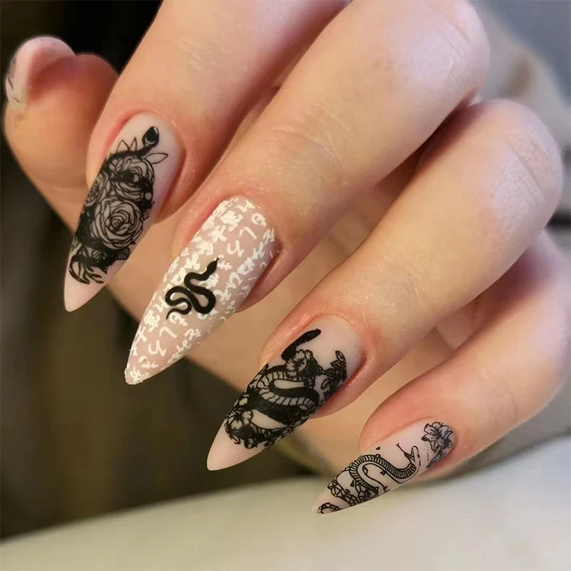 Kunstvolle Nagelverlängerungen im eleganten Stiletto-Stil mit kunstvollen floralen und grafischen Designs Karnz